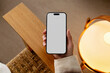 © Artem Podrez/Stocksy - Mockup Smartphone with white screen in cozy home