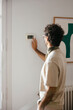 © BONNINSTUDIO/Stocksy - Man adjusting the temperature on the thermostat at home