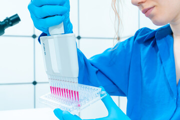 Poster - female genetic laboratory technician working with multi pipette and ninety-six well plate