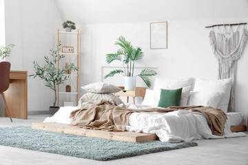 Wall Mural - Cozy bed with soft pillows and crumpled blanket in interior of light bedroom