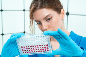 Canvas Print - female laboratory assistant in genetics laboratory working with multi pipette and ninety-six well plate