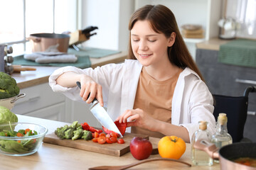 Poster - Young woman in wheelchair cutting bell pepper at home