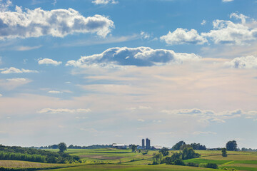 iowa farm and fields under a beautiful cloudscape on a sunny summer afternoon