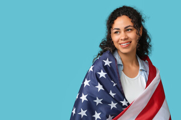 Wall Mural - Beautiful young happy African-American woman with USA flag on blue background