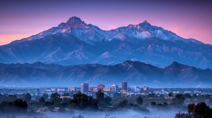 Wall Mural - Serene Sunrise Over Mountain Town with Snow-Capped Peaks and Misty Valley Providing a Picturesque and Tranquil Morning Landscape