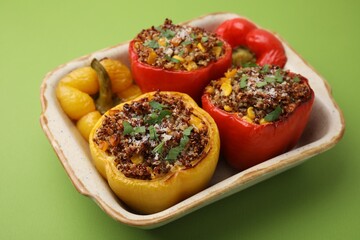 Wall Mural - Tasty quinoa stuffed bell peppers with corn in baking dish on light green table