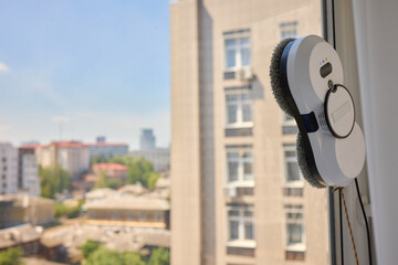 Wall Mural - A robotic white Automotive tire is cleaning a glass window