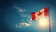 © Naret - Canadian flag flying high against a clear blue sky with the sun shining brightly in the background, creating a sense of pride and patriotism.