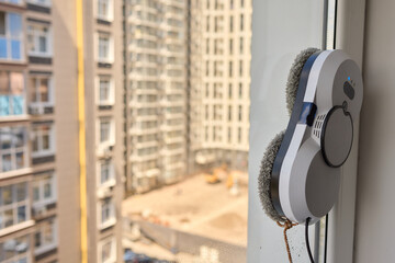 Wall Mural - A robotic white Automotive tire is cleaning a glass window