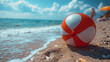 © Coffee Cafe Lover - A bright red beach ball sits alone on the sandy shore, waiting for summer fun