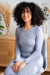 © nomad studio/Stocksy - woman with curly hair smiling indoors