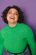 © VICTOR TORRES/Stocksy - Joyful young curvy woman laughing in vibrant green sweater