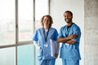 © BONNINSTUDIO/Stocksy - Confident doctors looking at camera at hospital