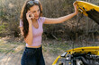 © Lea Jones/Stocksy - young woman with broken down car, opening the hood
