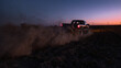 © Oleksandr Stalovierov/Stocksy - Pickup truck a cloud of dust from  the rear wheels.