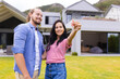 © Wavebreak Media - Young diverse couple are smiling while holding house keys, buying first home