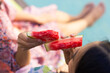 © Wavebreak Media - Two young biracial sisters enjoying slices of watermelon together, at home