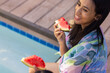 © Wavebreak Media - Biracial young girl enjoying watermelon by pool with friend, at home