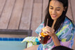 © Wavebreak Media - Young biracial girl enjoying drink by pool, copy space, at home