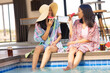 © Wavebreak Media - Two biracial young sisters enjoying watermelon while sitting by pool, at home