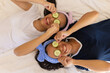 © Wavebreak Media - Two biracial young sisters lie on a bed with cucumber slices on their eyes, smiling, at home