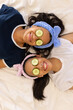© Wavebreak Media - Two biracial young sisters relaxing with cucumber slices on their eyes, at home