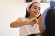 © Wavebreak Media - Biracial young girl applying face mask to her friend's face, both wearing headbands, at home
