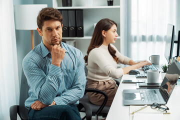 Wall Mural - Office worker smart man thinking creative project with looking at camera photo shooting portrait business using pen to pose profile with beautiful coworker at modern office at morning time. Postulate.