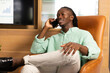 © Wavebreak Media - African American man talking on smartphone, smiling and relaxed in business office