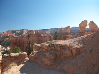 Hiking inside Bryce canyon, footpath between red rock hoodoos, Queens garden trail, sunny day