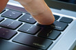 © Photo Sesaon - Finger of the computer user, he presses the delete button on the computer keyboard.