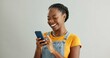 © CineLens/peopleimages.com - African woman, phone and texting in studio with smile, reading or thinking for contact by white background. Gen z person, girl and happy with smartphone for chat, meme or social network on mobile app