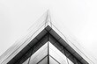 © KumCup - A high-contrast, monochrome photo capturing the angular architecture of a modern glass building against a grey sky.