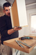 © astrosystem - Man working and assembling furniture in a new apartment.
