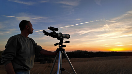Wall Mural - amateur astronomer observing solar eclipse and sun with a telescope and special solar filter.