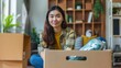 © Anurak - Young Woman Packing Boxes for Moving Day.