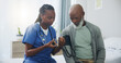 © peopleimages.com - Hospital, senior man and nurse with monitor for blood pressure, medical test or cardiovascular. Black people, mature patient or caregiver for hypertension diagnosis, healthcare or consultation in bed