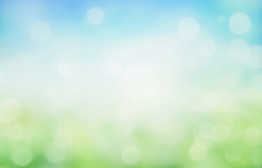 summer background, blurred green grass and blue sky with bright bokeh. blurry abstract summer backgr