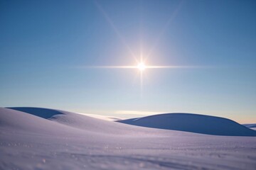Wall Mural - A breathtaking winter landscape unfolds below, with snow-covered mountains and hills reaching towards a clear blue sky with wispy clouds