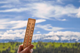 Pogoda w górach, termometr wskazujący temperaturę na tle krajobrazu z górami 