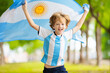 © famveldman - Child running with Argentina flag. Argentinian fan