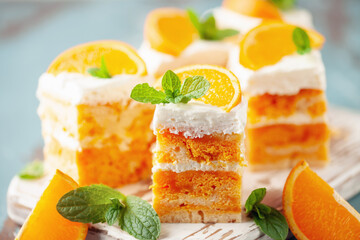 Wall Mural - Slices of creamsicle cake on wooden cutting board. Orange fruit cake.