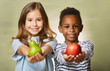 © Rulan - Young girl and boy offering a green pear and a red apple