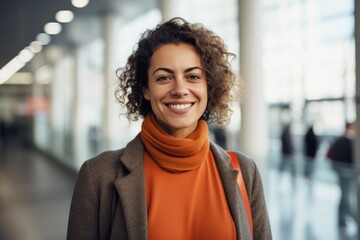 Wall Mural - Portrait of a grinning woman in her 30s dressed in a warm wool sweater in front of sophisticated corporate office background