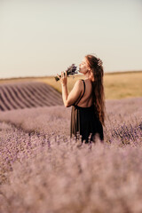 Wall Mural - woman stands in a lavender field of purple flowers, holding a bouquet of flowers. The scene is serene and peaceful, with the woman taking a moment to enjoy the beauty of nature.