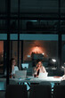 © peopleimages.com - Employee, women and laptop in office at night with documents for deadline or overtime as accountant. Business, partner and data capture for financial reviews, records and auditing in company report