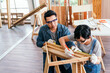 © artitwpd - Close-up carpenter hands wearing work gloves draw the cutting line with a pencil on a wooden board. Construction industry, carpentry workshop. Carpenter at work on wooden boards. Carpentry concept.