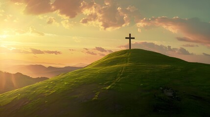 Cristian cross on top of a green hill at sunset