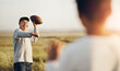 © peopleimages.com - Kid, dad and throw with football on grass field for outdoor sports, exercise and child development. Smile, man and happy with son in nature for teaching, practice and bonding together on fathers day