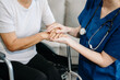 © Nuttapong punna - Young nurse helping elderly woman walk in the room, holding his hand, supporting. Treatment and rehabilitation after injury